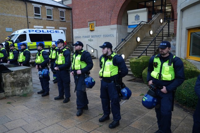 Police watch protesters outside the Bell Hotel in Epping, Essex, believed to be housing asylum seekers, where there have been a number of demonstrations, after police charged 38-year-old asylum seeker Hadush Gerberslasie Kebatu with sexual assault following an incident where he is alleged to have attempted to kiss a 14-year-old girl. Picture date: Thursday July 24, 2025. PA Photo. The police and Government are ready to respond if violent protests over the asylum system spread following events in Epping, a Cabinet minister said. Business Secretary Jonathan Reynolds said he could understand people's frustrations at hotels being used to house asylum seekers but insisted that had come down from around 400 hotels to "just over 200". Photo credit should read: Lucy North/PA Wire