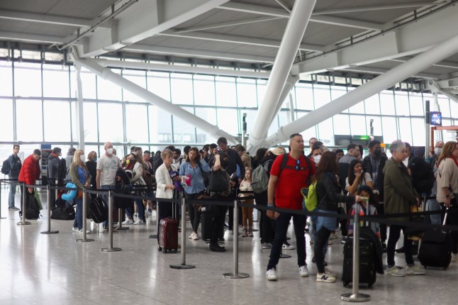 Passengers queue to enter airport security ahead of the Easter Bank Holiday weekend, at Terminal 5 of Heathrow Airport, in London, Britain, April 14, 2022. REUTERS/Hannah McKay