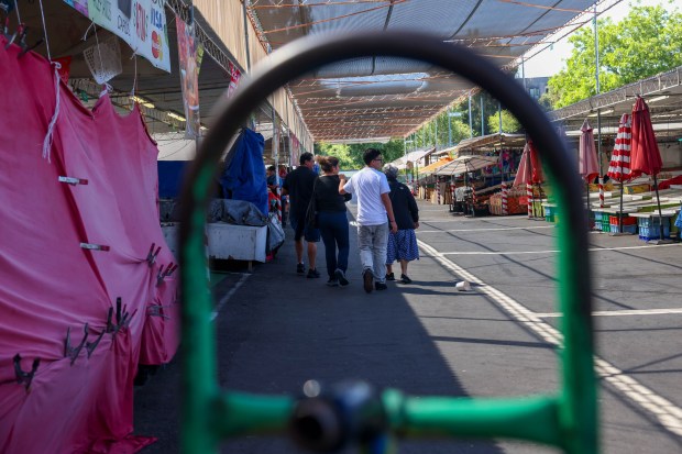 Customers walk along the isolated Flea Market in San Jose,...