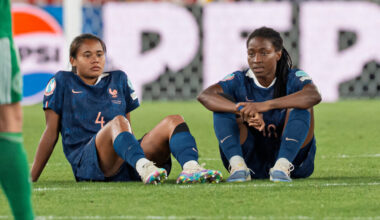 Oriane Jean-Francois and Alice Sombath sit on the pitch at St. Jakob-Park in Basel, Switzerland after losing to Germany on penalties in the UEFA Women's Euro 2025 quarterfinal.