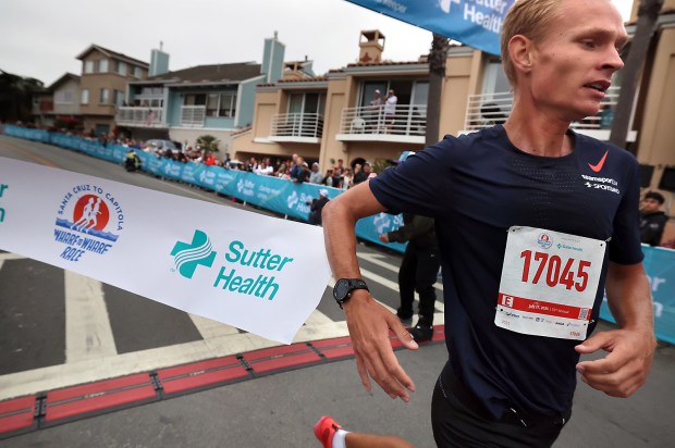 Men's winner Arturs Medveds. of Aizpute, Latvia, breaks the tape at the Capitola finish line on Sunday at the 2025 Wharf to Wharf race. (Shmuel Thaler - Santa Cruz Sentinel)