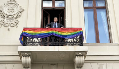 Ulf Kristersson on balcony of Sagerska Palatset, the offical residence of the Swedish PM, balcony decorated with Pride flag