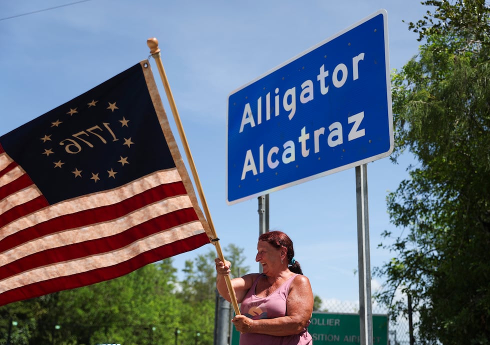 Rana Mourer waves an American flag outside of the migrant detention facility dubbed "Alligator...
