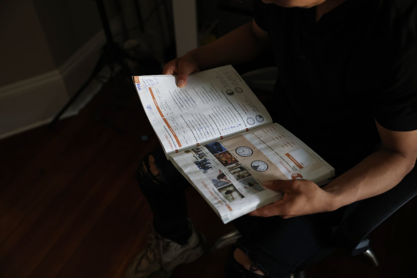 Seidner Reynoso, 20, held the book he used in last year in his English class through the Massachusetts Migrant Education Program in Springfield. Reynoso, who's from Guatemala, is learning English through the program. 