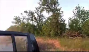 Ukrainian soldiers escaping their vehicle seconds before an FPV drone impacts it
