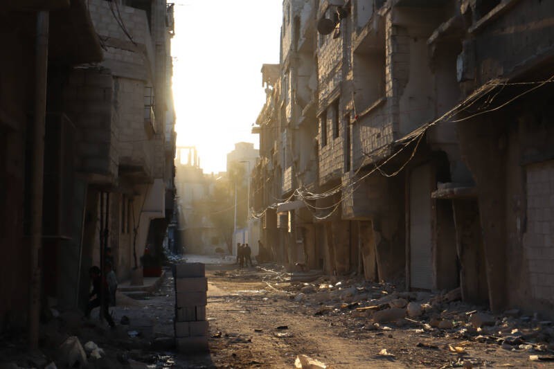 A group of boys gather in a side street of Yarmouk camp at sunset, 30/4/2025 (Natacha Danon/Syria Direct)
