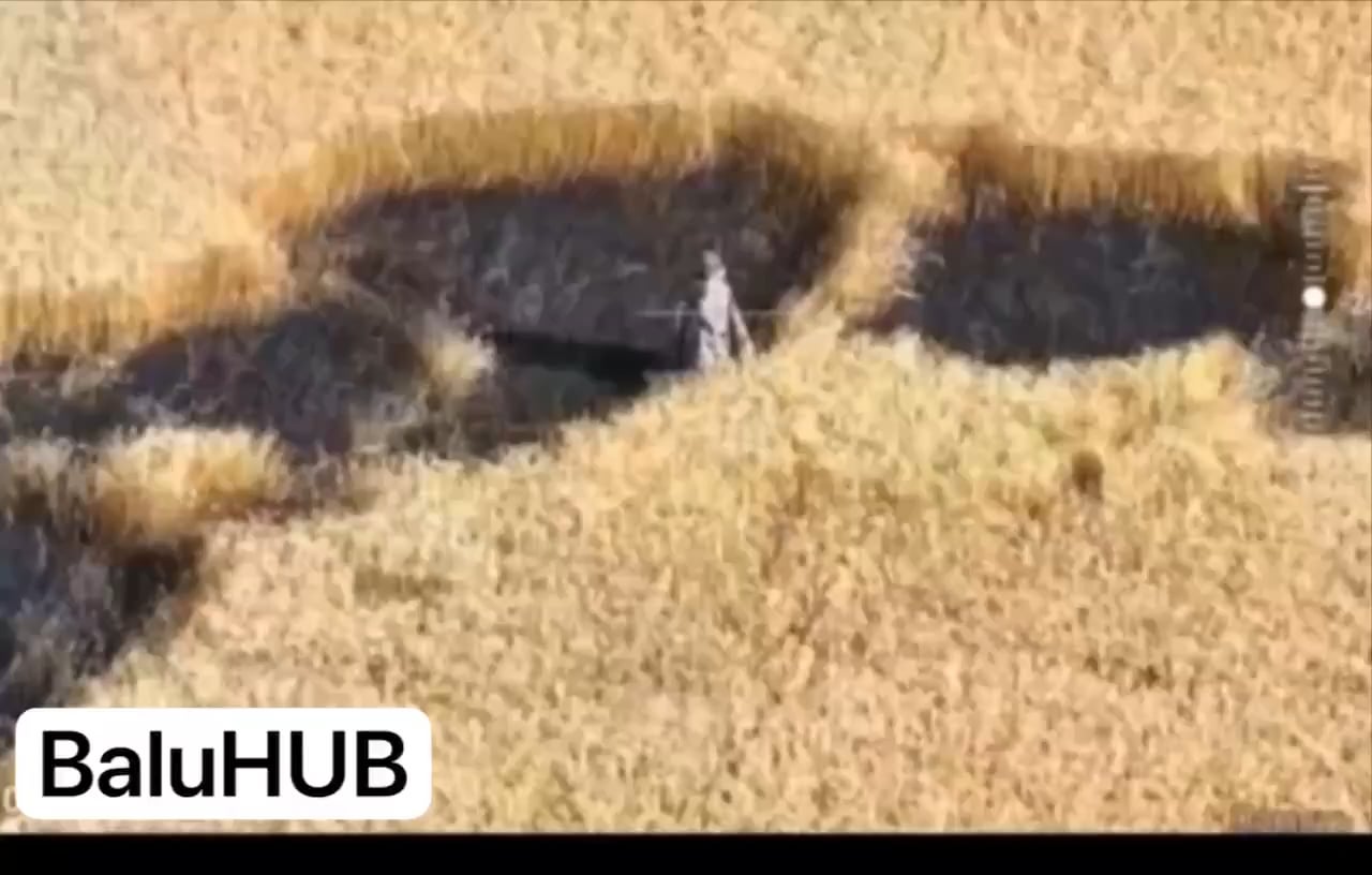 Footage of a Russian soldier wearing a heat-insulating anti-drone poncho trying to advance through a grain field during the day is getting hit by a Ukrainian FPV quad.