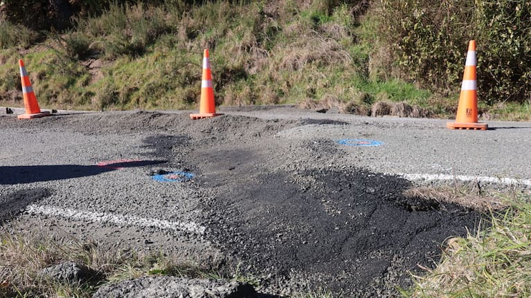 A historic landslide shifted during the rain, buckling the road which was built atop it.