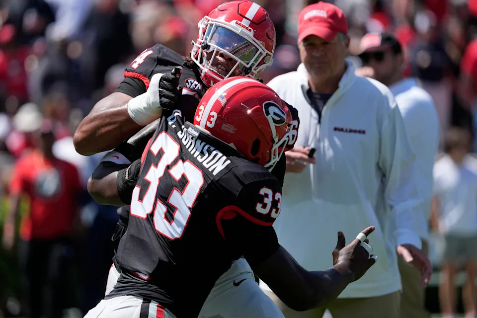 Georgia outside linebacker Quintavius Johnson warms up with Georgia offensive lineman Jahzare Jackson (64)