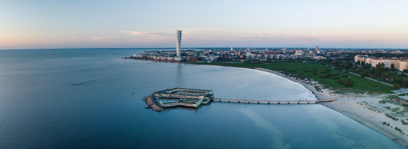 A body of water with a city in the background

AI-generated content may be incorrect.