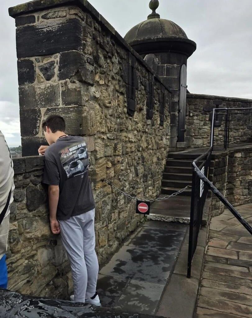 Scratching "Whatever" into the wall of Edinburgh Castle