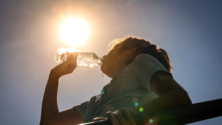 Boy drinking water from a bottle on a sunny hot day