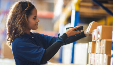 woman using an handheld terminal to check packages