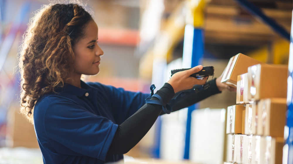 woman using an handheld terminal to check packages