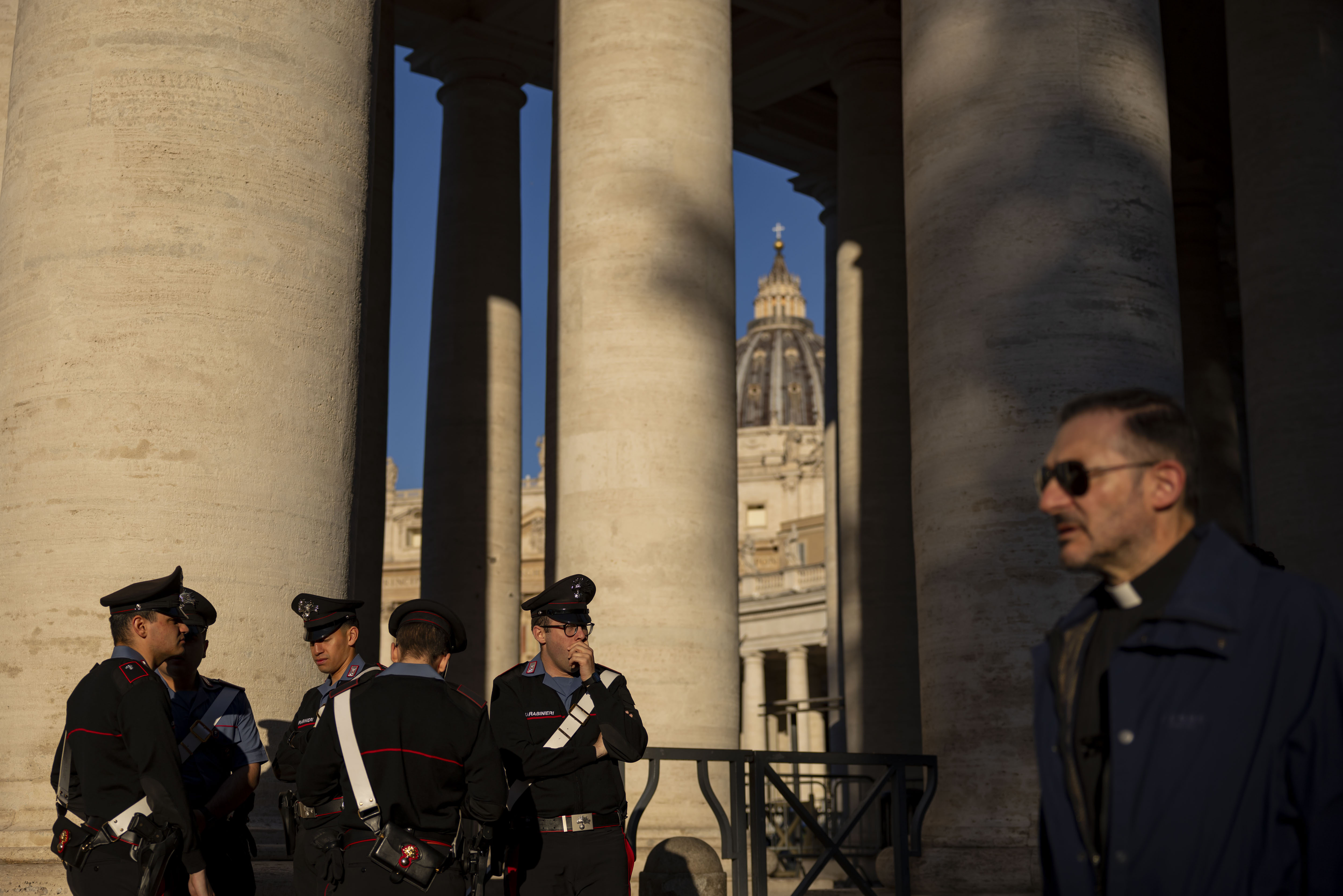 Carabinieri officers and a priest pass through St. Peter's Square on May 16, 2025, before the installation of Pope Leo XIV at the Vatican. (Brian Cassella/Chicago Tribune)