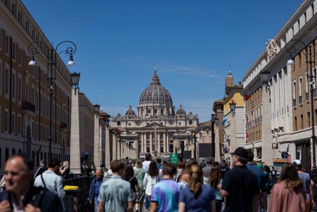 People walk down Via della Conciliazione near St. Peter's Square on Saturday, May 17, 2025, before the installation of Pope Leo XIV at the Vatican. (Brian Cassella/Chicago Tribune)