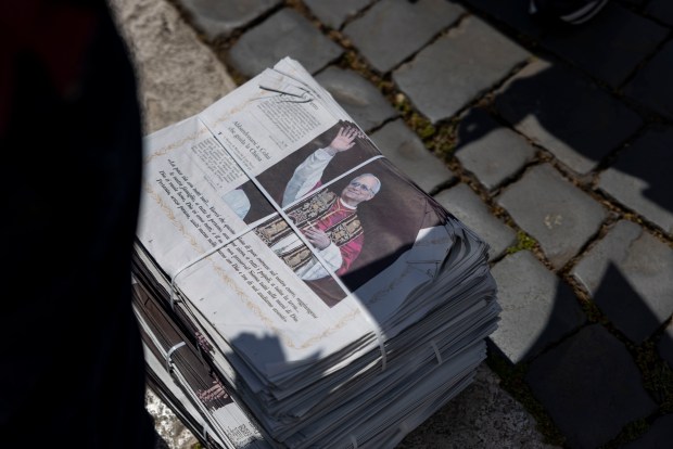 Attendees pick up newspapers featuring Pope Leo XIV after his installation Mass in St. Peter's Square on Sunday, May 18, 2025, at the Vatican. (Brian Cassella/Chicago Tribune)