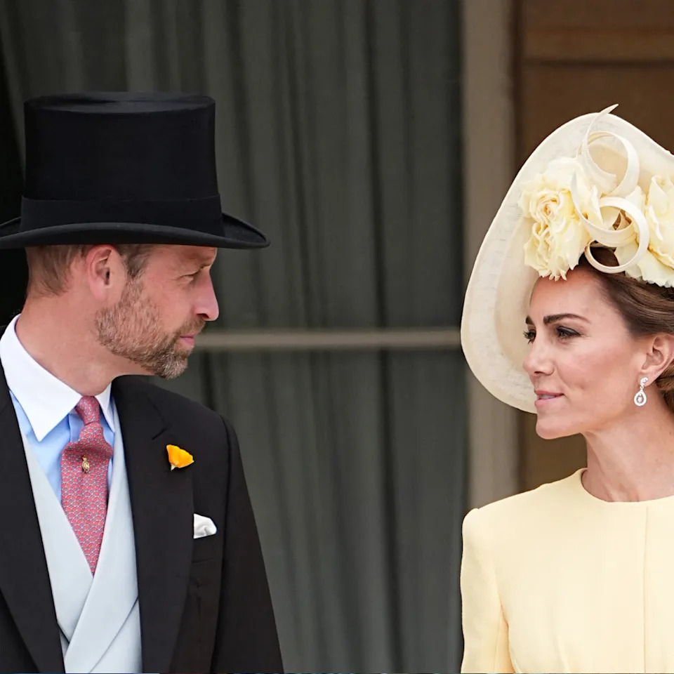  Prince William wearing a top hat talking to Princess Kate wearing a yellow dress and hat. 