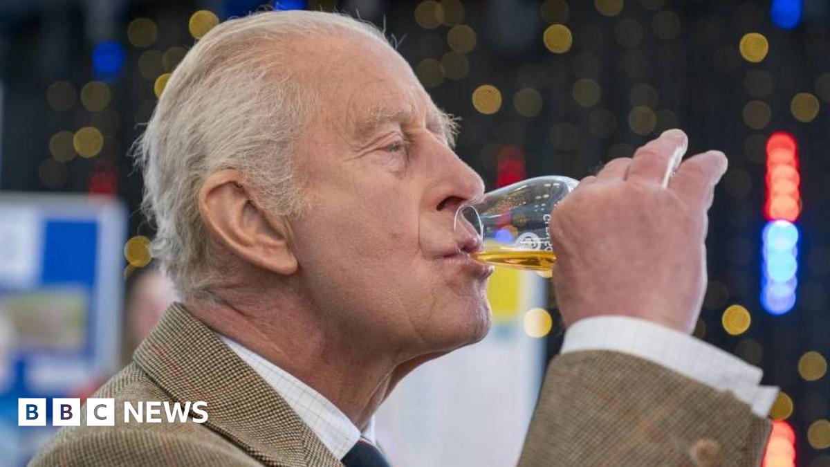 King Charles, with his lips pursed as he sips from a glass of whisky