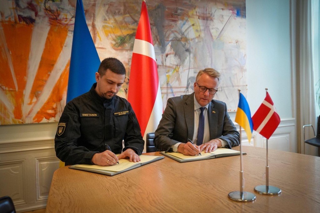 Ukrainian and Danish ministers signing an agreement.