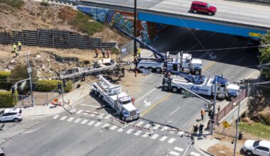 Crane drives off overpass in California, blocks road; driver hospitalized