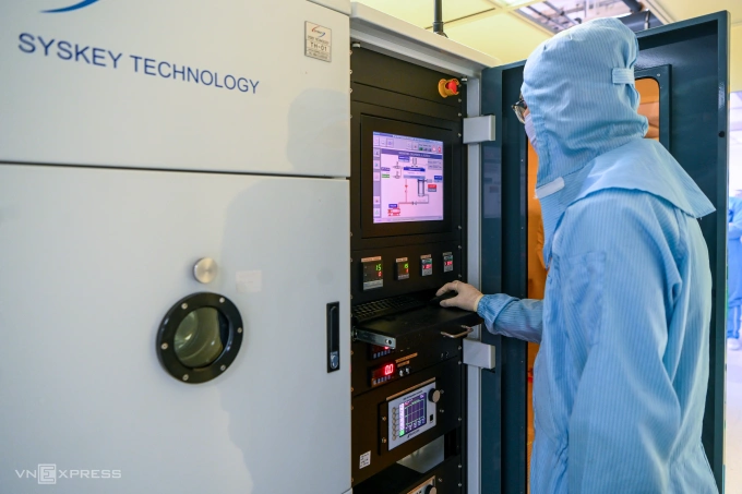 Nguyen Trung Kien, a PhD student from the faculty of physics, operates the multi-source thermal evaporation system inside a US$5-million semiconductor laboratory at the University of Science, Vietnam National University in Hanoi. Photo by VnExpress/Giang Huy