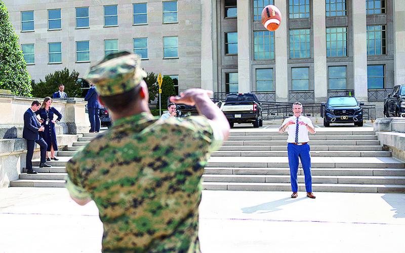 Jacksonville Jaguars NFL player and U.S. Naval Academy graduate Marine Corps 2nd Lt. Rayuan Lane III tosses a football with Defense Secretary Pete Hegseth outside the Pentagon's river entrance during Lane's Pentagon visit, July 2, 2025.