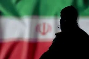 An illustrative image of an Iranian agent in the backdrop of an Iranian flag. (photo credit: SHUTTERSTOCK)