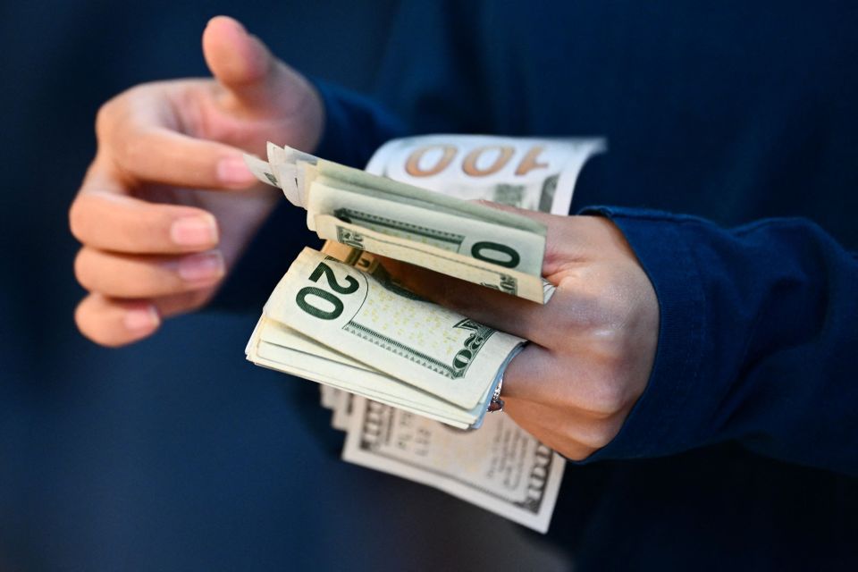 Person counting US dollar bills.