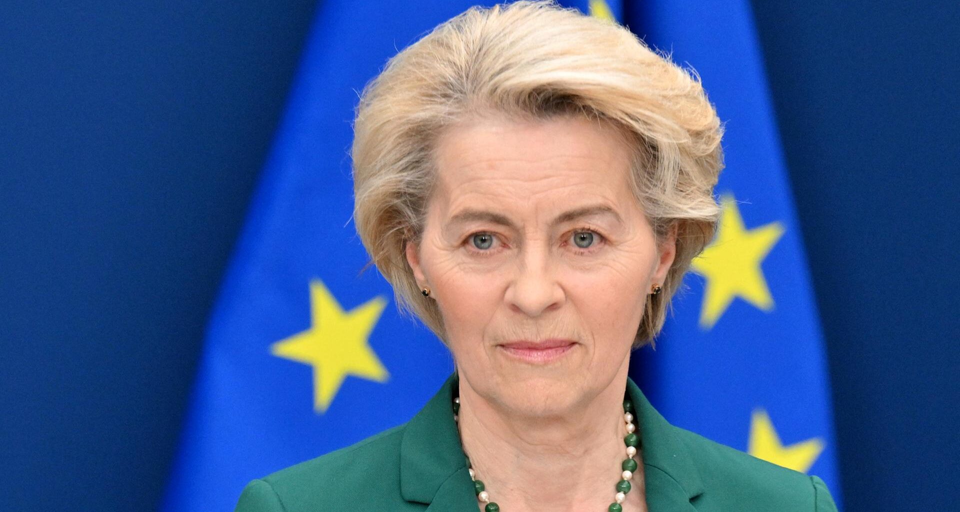 EU-Kommissionspräsidentin Ursula von der Leyen steht vor einer europäischen Flagge und schaut ernst.