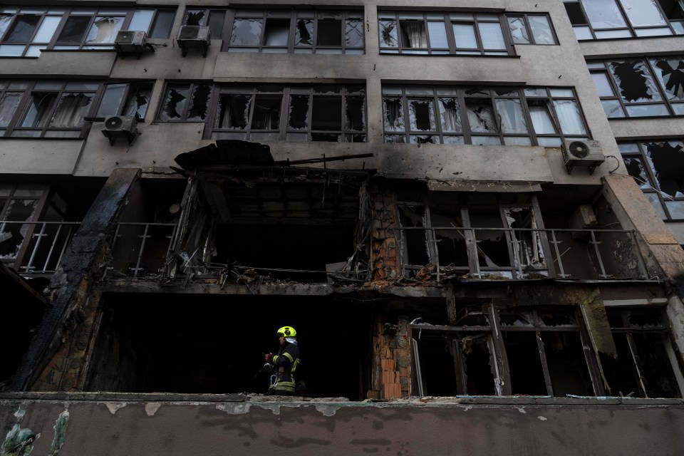 Firefighter at fire-damaged residential building.
