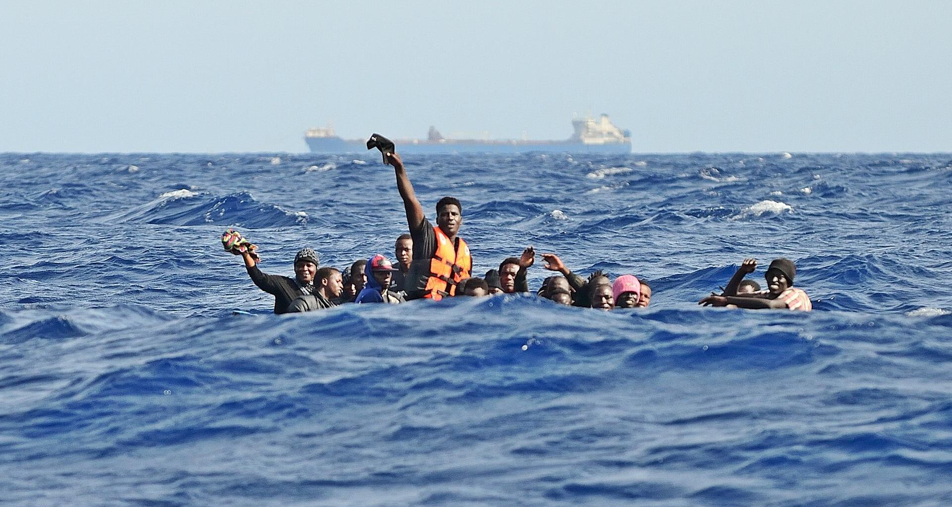 Migration über das Mittelmeer: Ein Holzboot mit etwa 30 Menschen an Bord ist bei hohen Wellengang in Seenot geraten. Die Männer rufen um Hilfe.