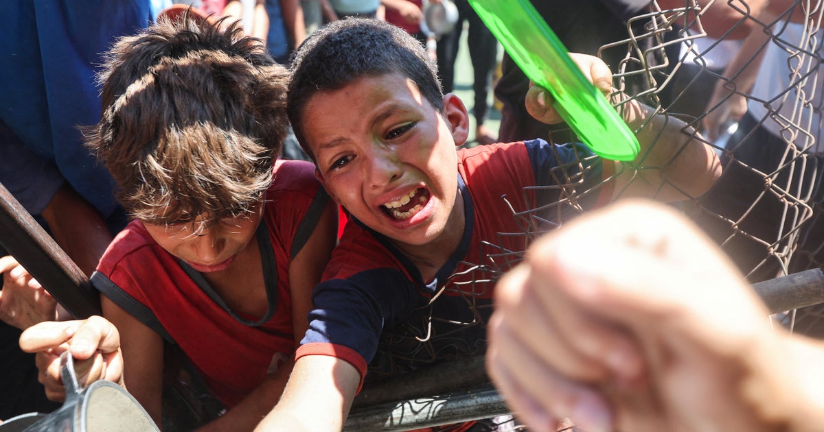 Palestinians gather to receive food from a charity kitchen, amid a hunger crisis, in Nuseirat