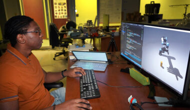Denilo at a computer examining his robot on the screen