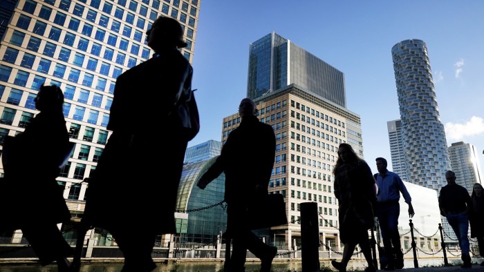 Commuters walk through Canary Wharf in London