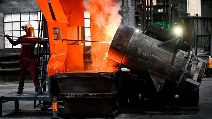 A foundry worker handles molten metal