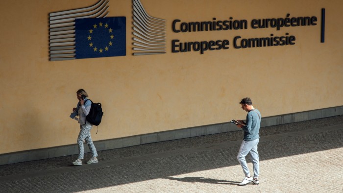 Pedestrians pass the Berlaymont building, headquarters of the European Commission, in Brussels