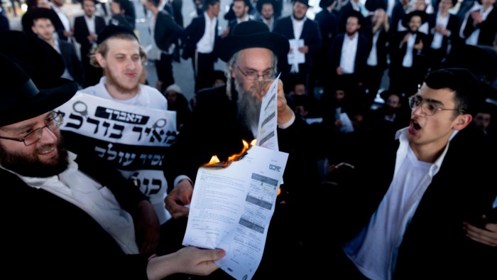 Ultraorthodox Jewish men burn conscription orders during a protest last month in Bnei Brak
