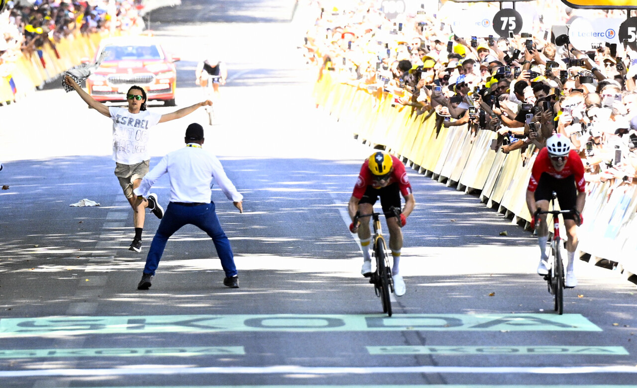 Tour de France à Toulouse. Un homme franchit la barrière et court à côté des coureurs à l'arrivée de l'étape