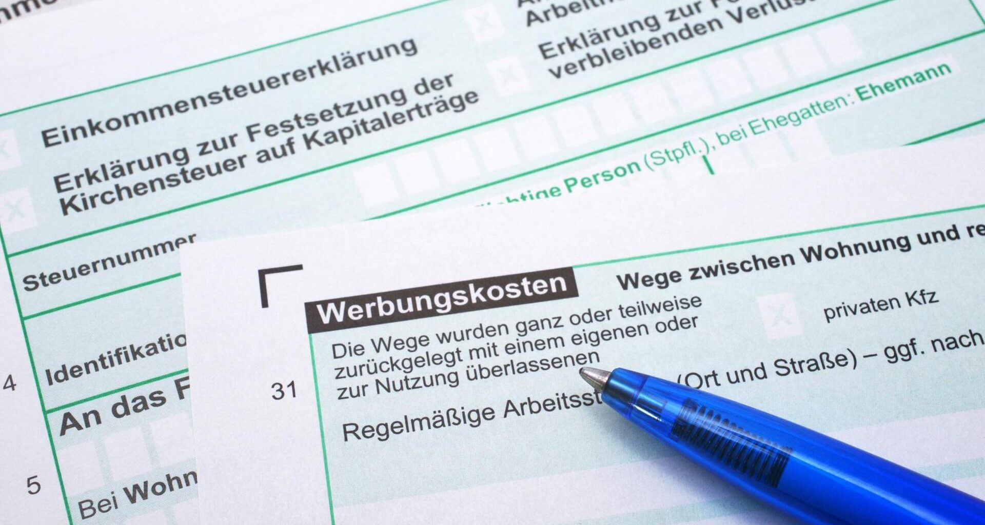 Auf dem Bogen für eine Steuerklärung liegt ein blauer Kugelschreiber.