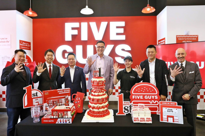 Kim Dong-seon (center), the third and youngest son of Hanwha Group Chairman Kim Seung-youn, poses with company official at the 1st anniversay of Five Guys Korea in June 2024 (Courtesy of FG Korea)