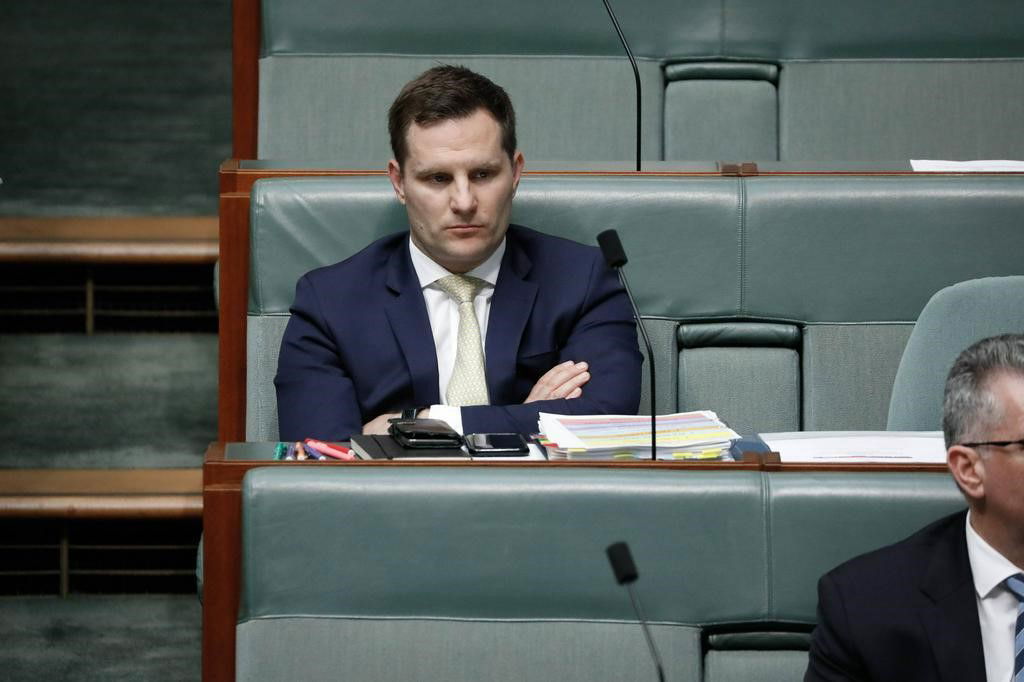 Liberal MP Alex Hawke sits with arms crossed in the House of Representatives chamber.
