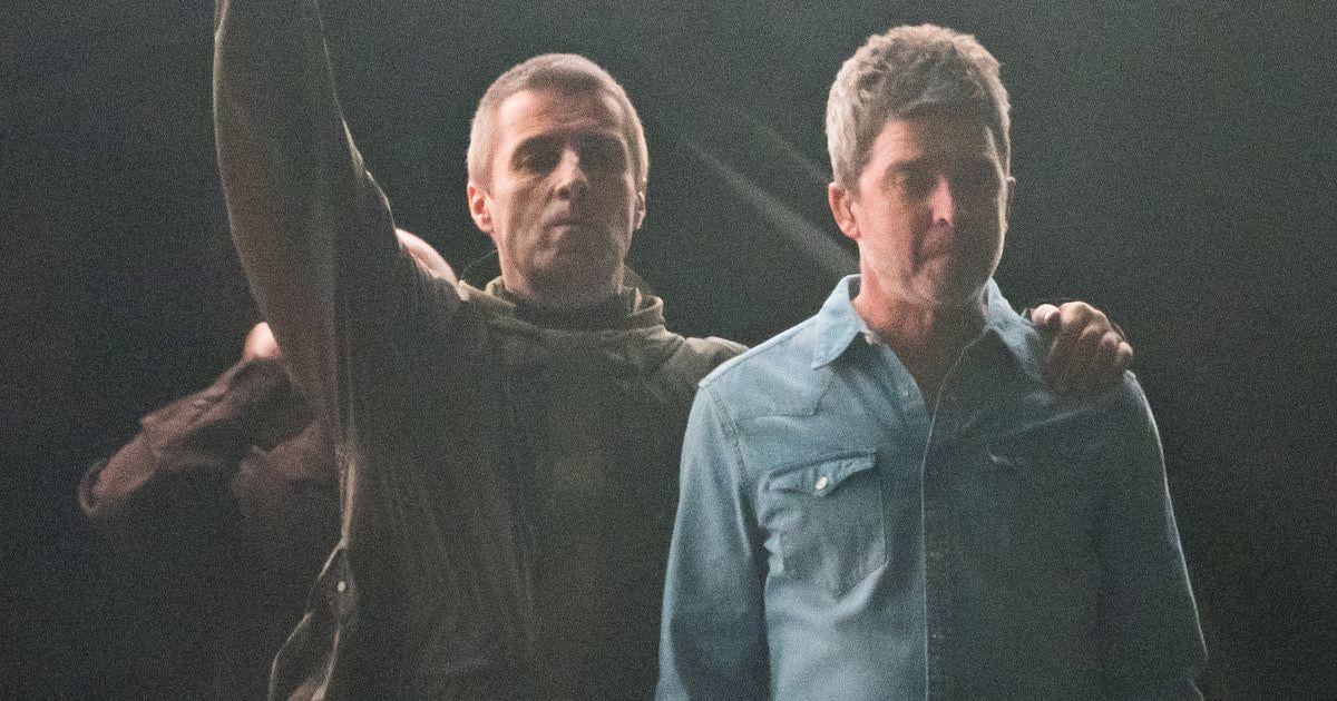 Liam and Noel Gallagher embrace on stage as brothers reunite for Oasis tour