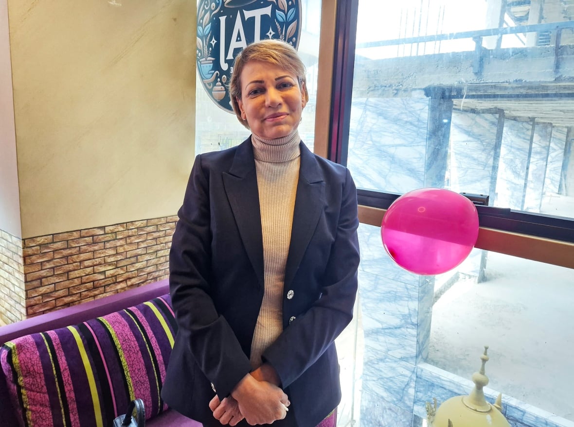 A woman stands in a restaurant.