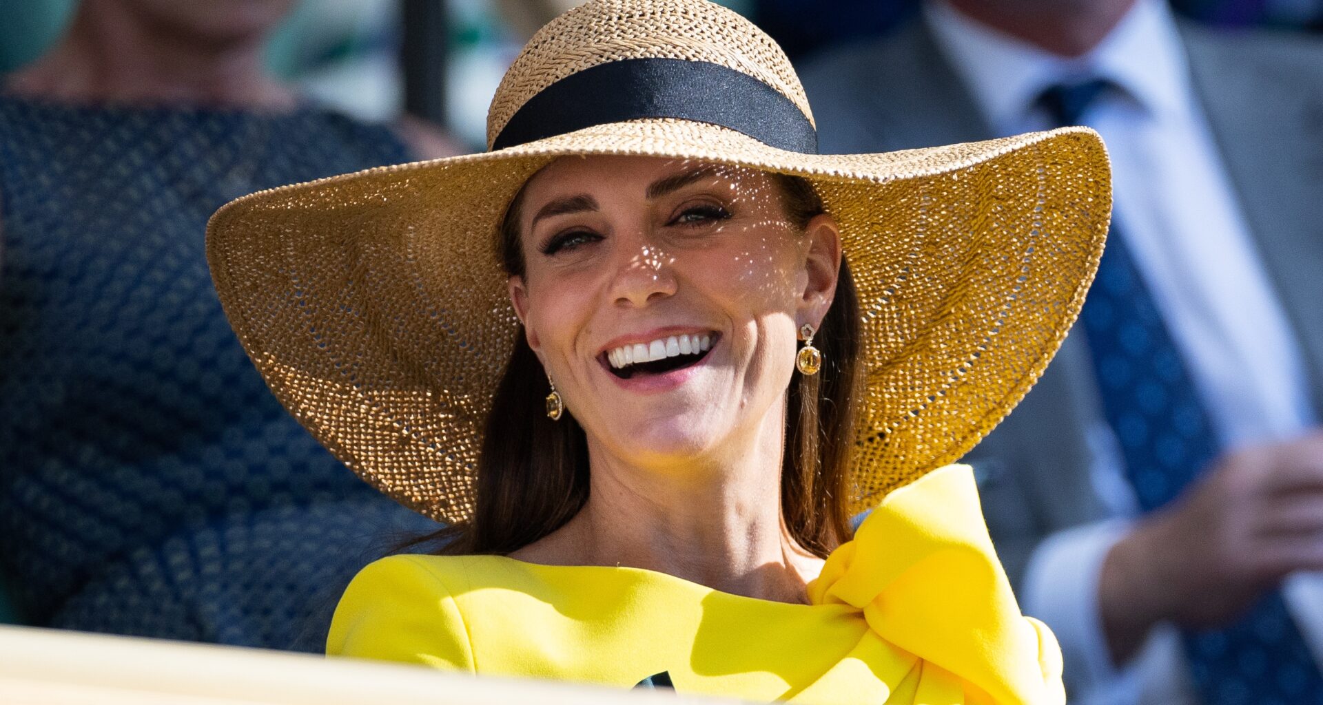 Catherine, Princess of Wales smiles, wearing a sunhat, in the royal box during the Men's Doubles Final at Wimbledon 2022