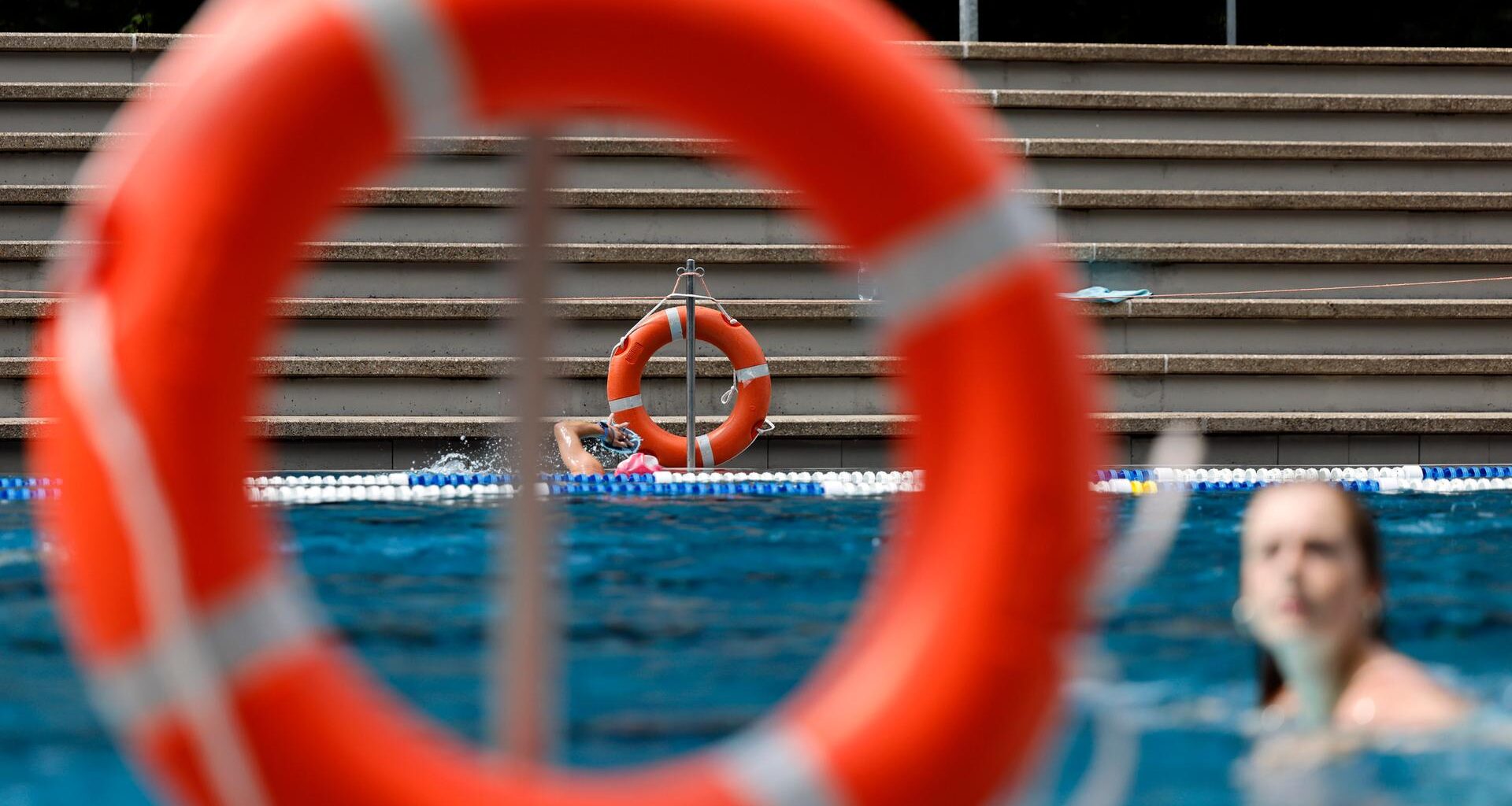 Rettungsringe hängen am Rand eines Schwimmbads.