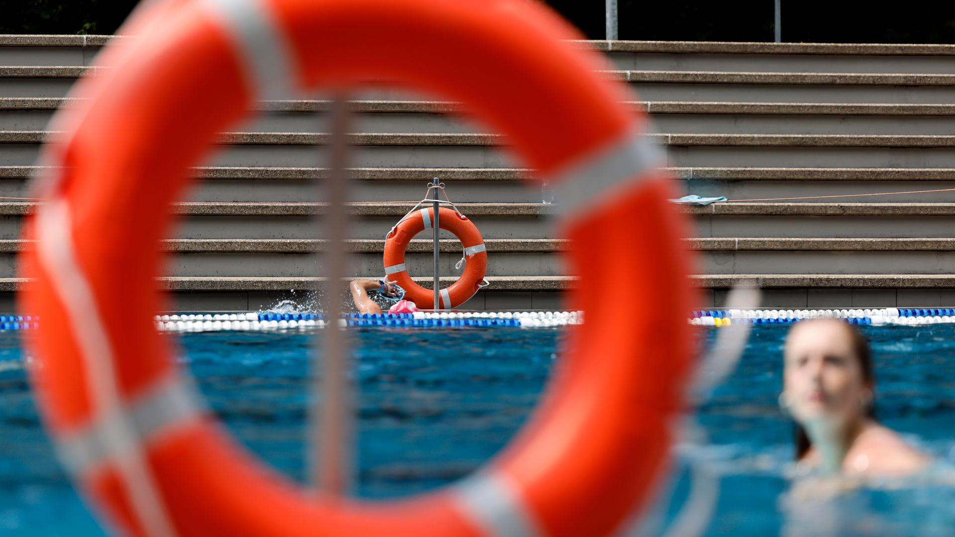 Rettungsringe hängen am Rand eines Schwimmbads.