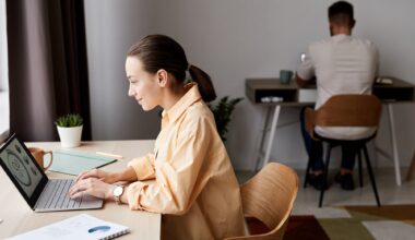 Side view of young confident brunette businesswoman looking at graphic data