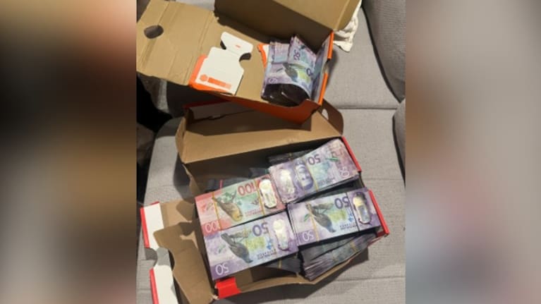 Stacks of cash stored in shoe boxes.