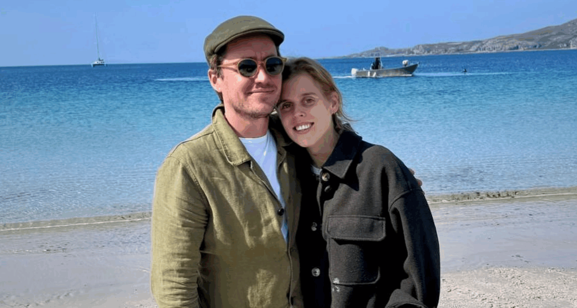 Princess Beatrice and Edoardo Mapelli Mozzi wearing green jackets on the beach and smiling